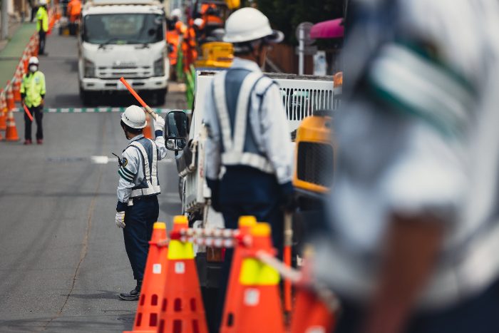 路上で交通誘導をするスタッフ